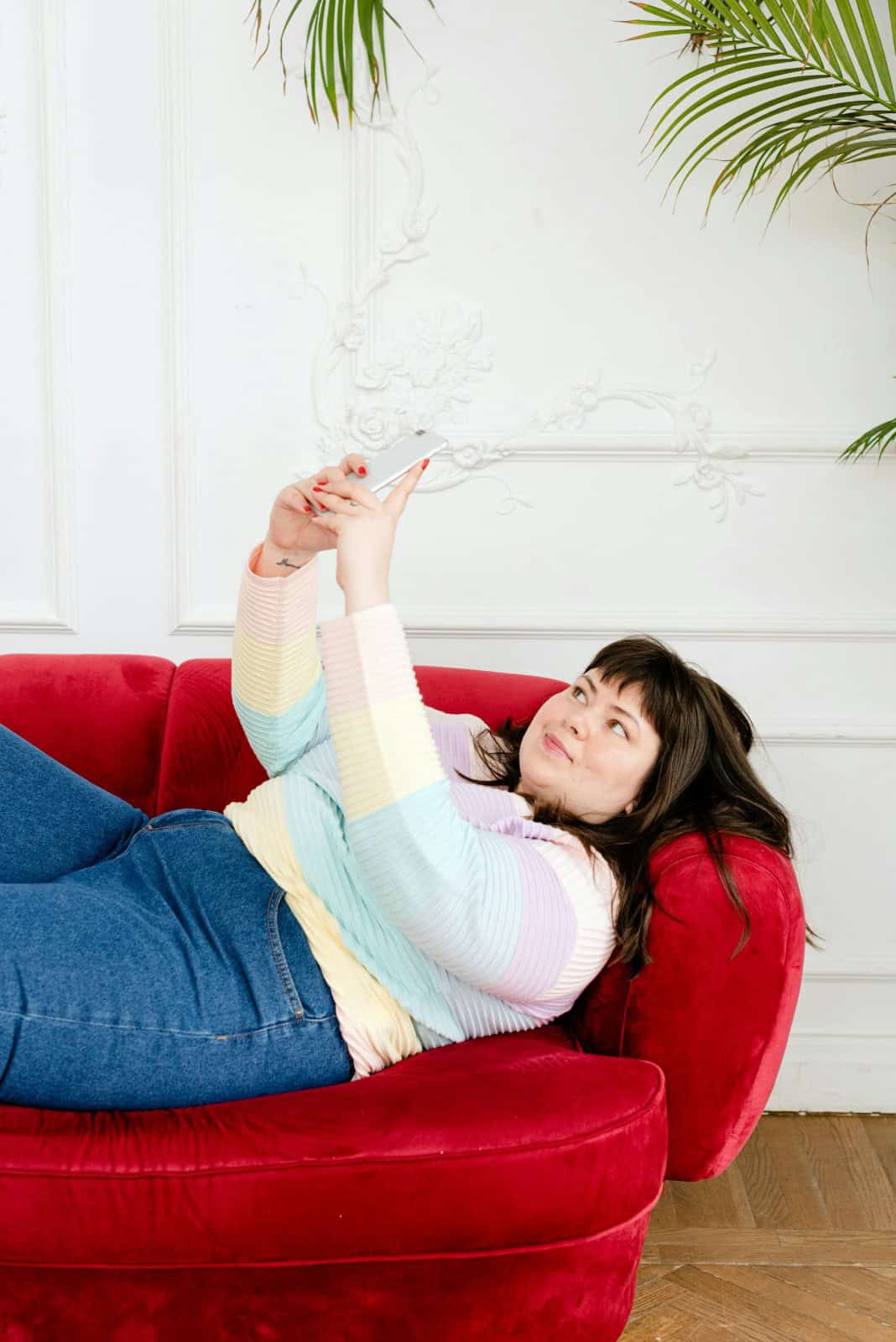 Mujer grabándose acostada en un sofá