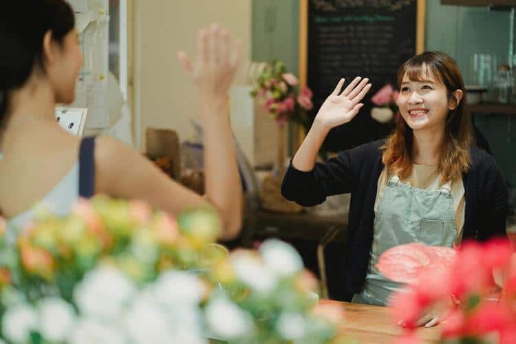 Dos empleadas de tienda felices cuidan de floristería