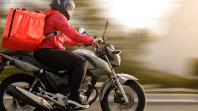 Repartidor en moto con apoyo en tienda