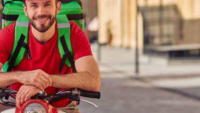Repartidor en moto con apoyo en tienda